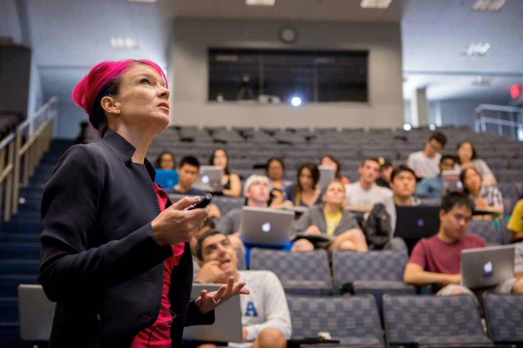 an instructor teaches a class in a full classroom