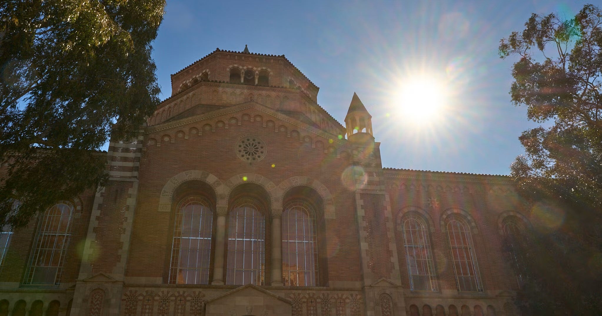 the sun shining behind powell library on ucla campus